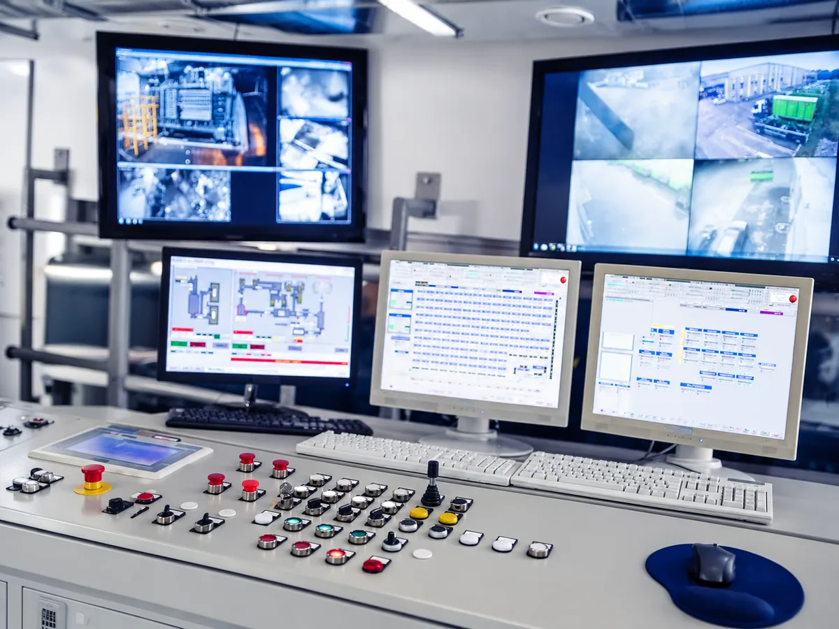 Control room operator desk with monitoring screens, push buttons and a control panel