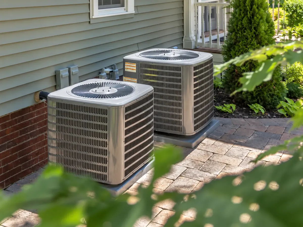 Two outdoor air-conditioning condenser units beside a building